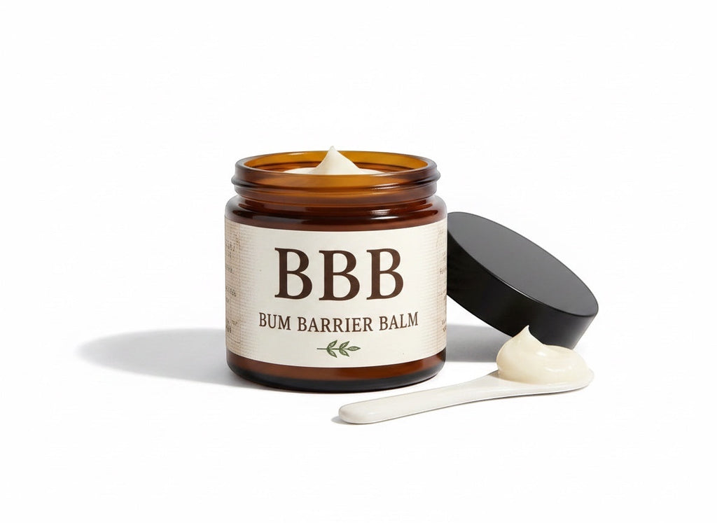 The Beef Bus Bum Barrier Balm in an amber glass jar with a small white scoop of natural tallow skincare cream.